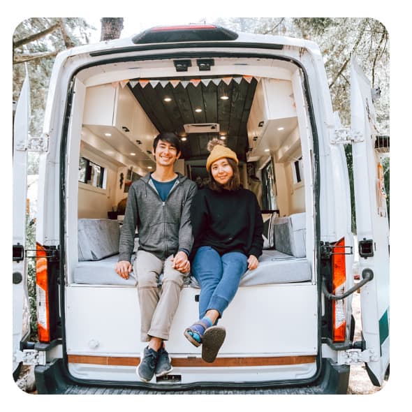 Man and woman sitting in the back of a camper van
