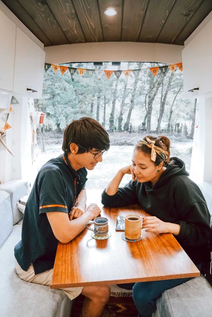 Eric and Yuko sitting inside their camper van