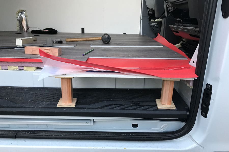 Van floor showing the top floor boards and red underlayment