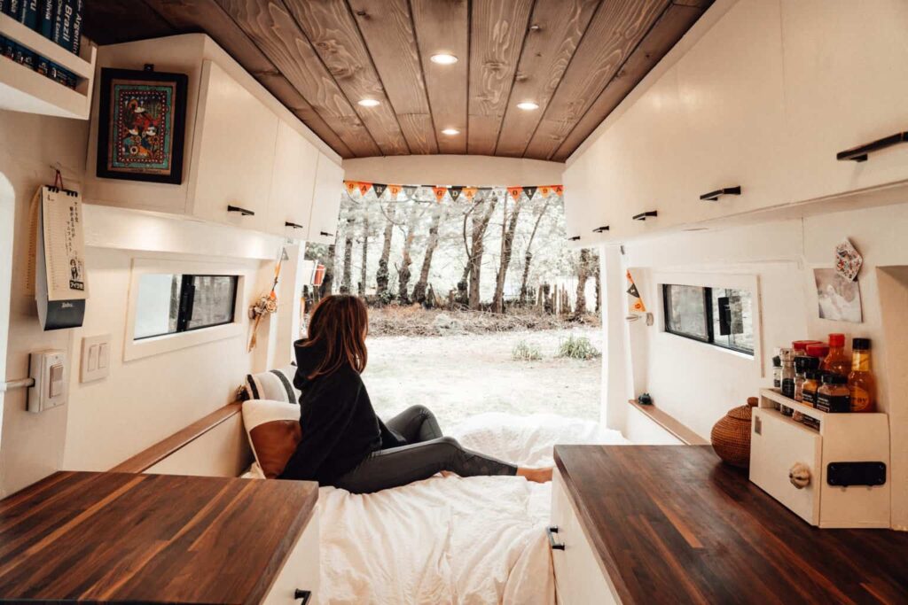 Yuko sitting out the back of a camper van with the back doors open