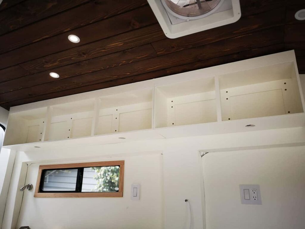 Overhead cabinet attached to wall inside camper van