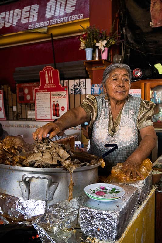 Lady selling barbacoa soup in a market in Mexico