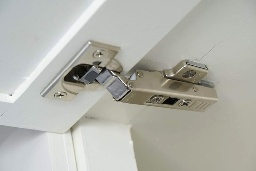 Blum soft-close hinges installed on a white overhead cabinet front