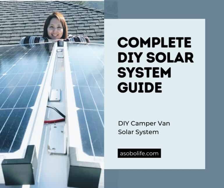 Woman standing in front of two solar panels that are mounted on top of a camper van