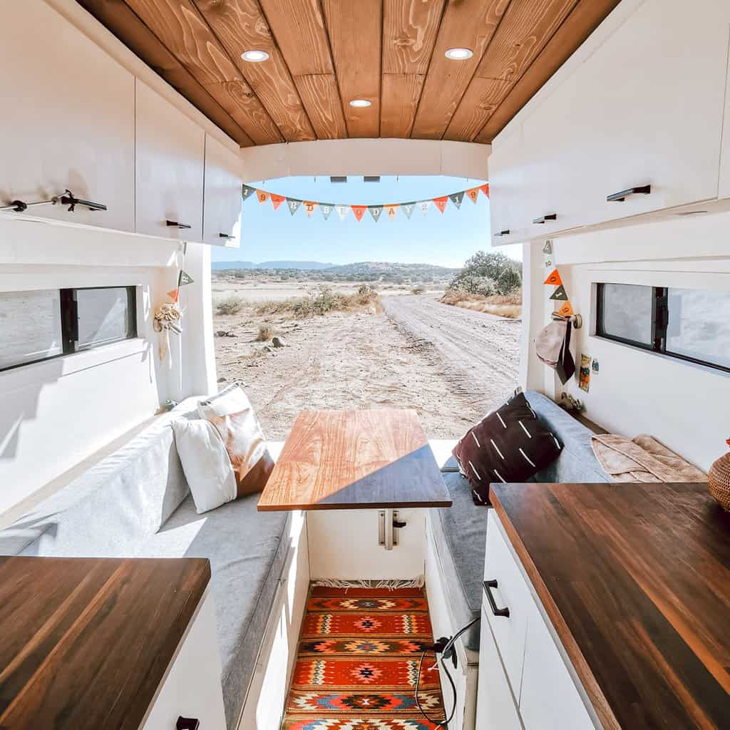 Back half of a camper van with the dinette and kitchen counters