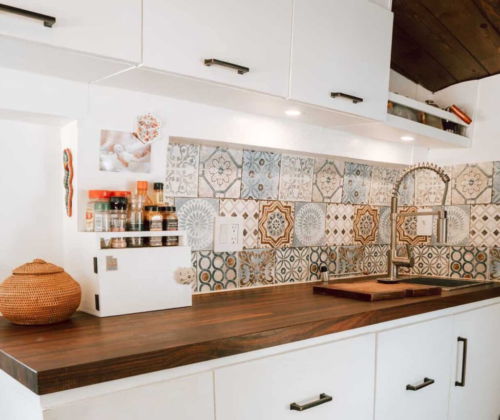 Camper van kitchen with counter, sink, spice rack, and faucet