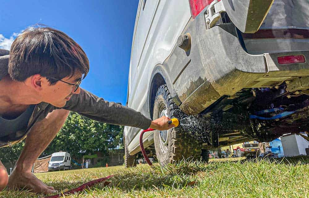 Spray washing the underside of a camper van's chassis