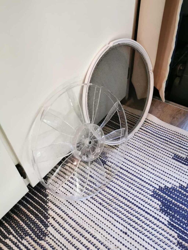 Maxxair mesh and fan blades resting on the floor of a camper van
