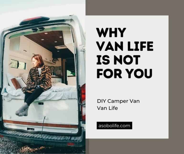 A woman sitting out the back of a camper van dressed in a shawl