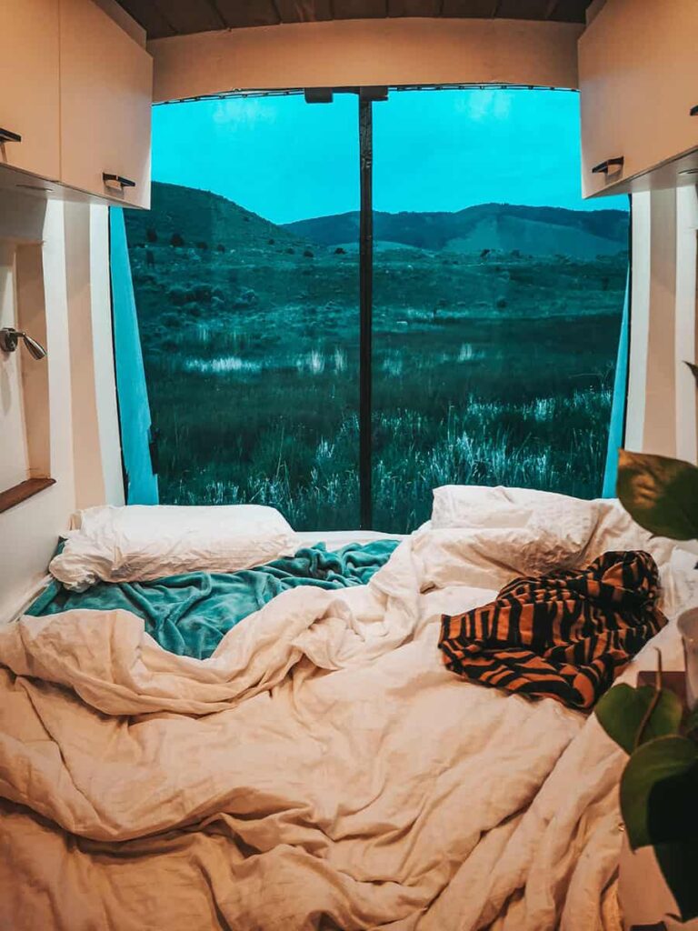 Camper van bed with pillows and blanket