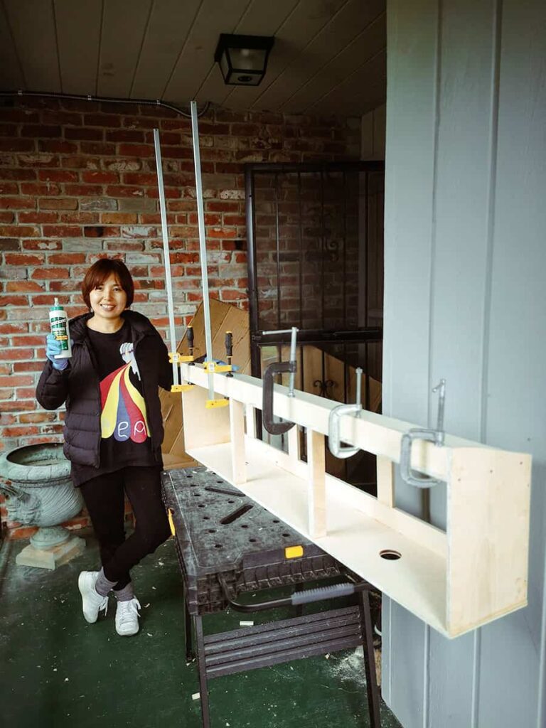 Yuko standing behind our unfinished overhead cabinets