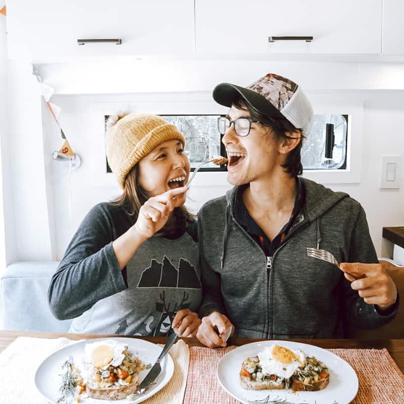 Eric and Yuko eating lunch inside their camper van