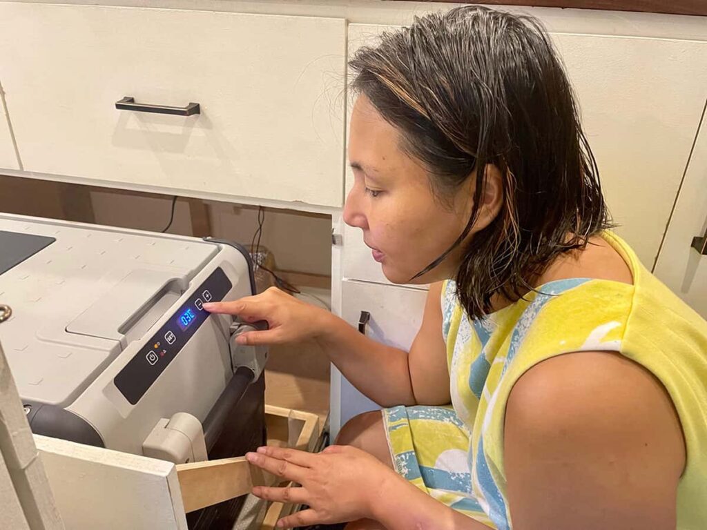 Yuko pressing the controls on her 12V Dometic fridge