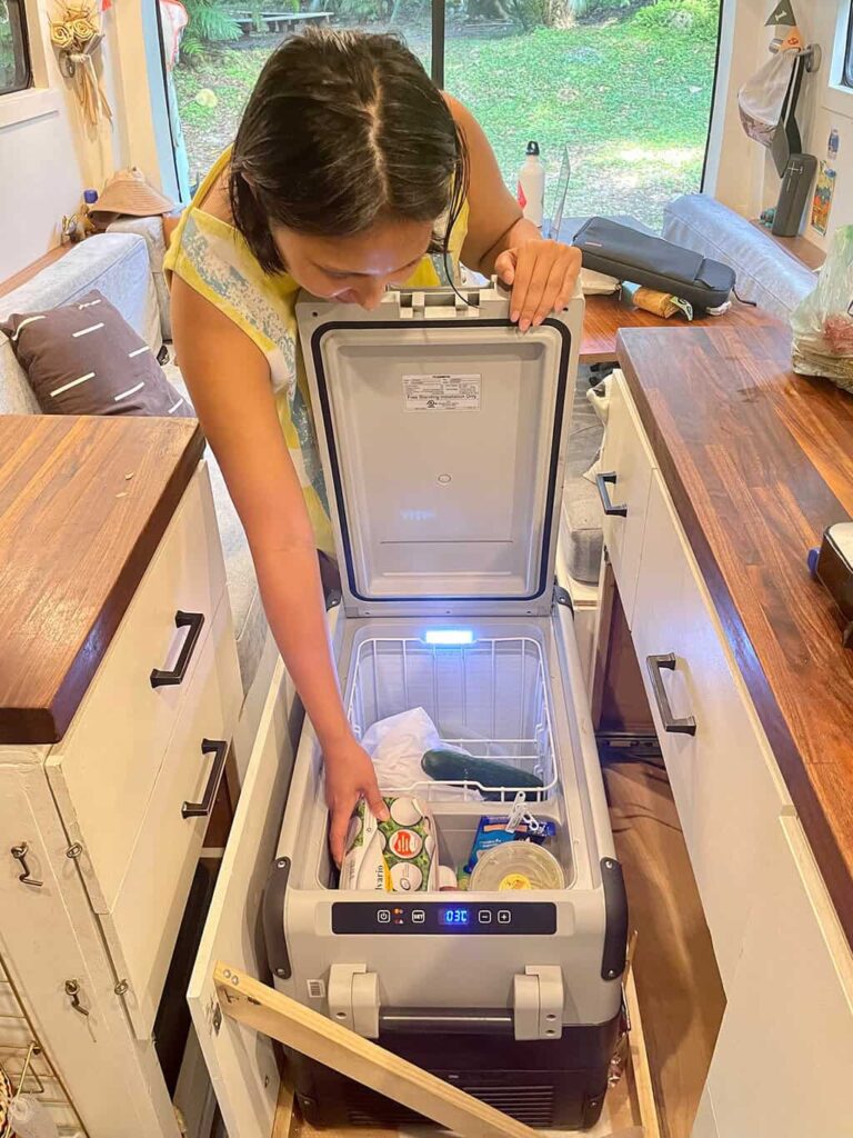 Woman opening the top lid of a Dometic 12V fridge