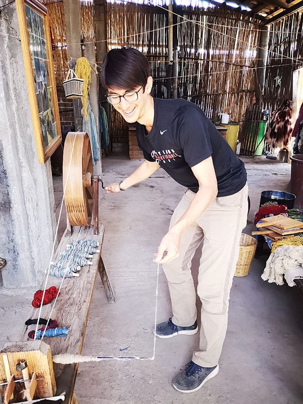 Eric trying his hand at spinning wool