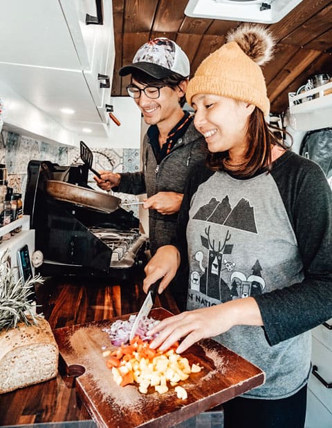 Couple cooking in a camper van