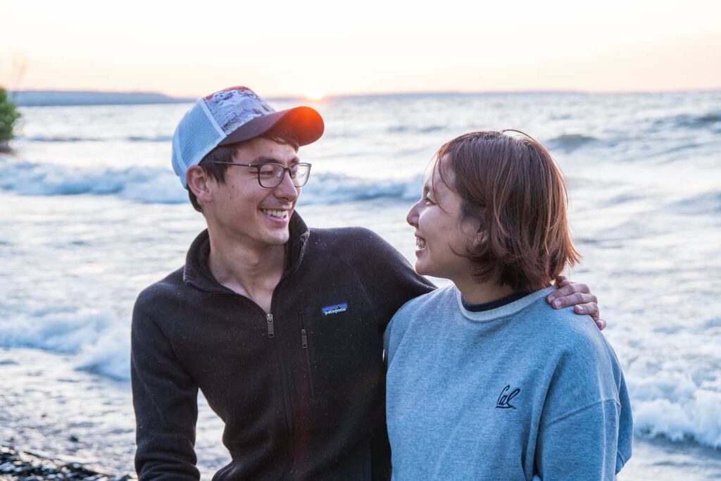 Couple posing for a photo outside in front of the ocean