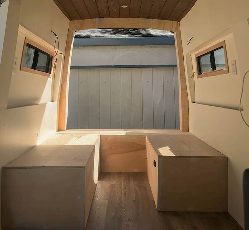 Completed camper van bed after adding the plywood paneling