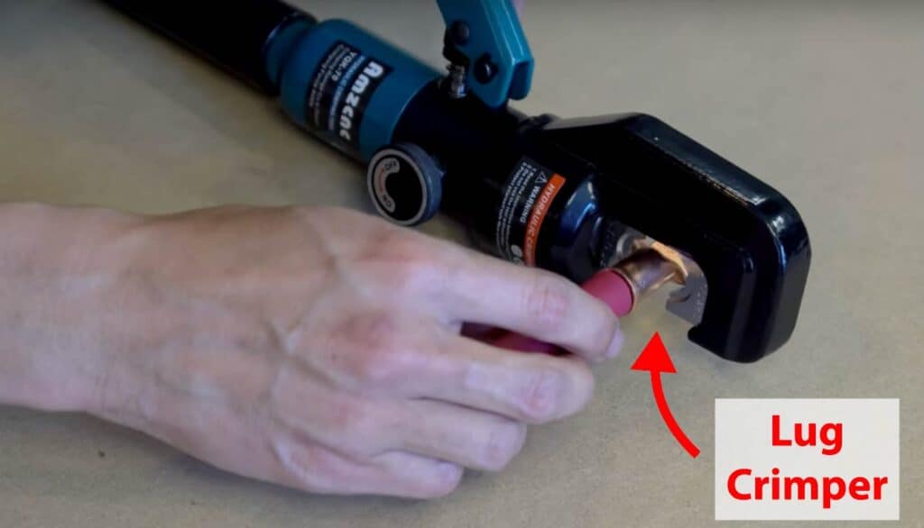 Using a hydraulic lug crimper to crimp a copper lug terminal onto electrical cable.