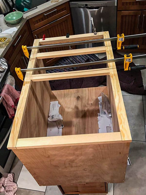 Using clamps to keep the kitchen counter frame together until wood glue dries