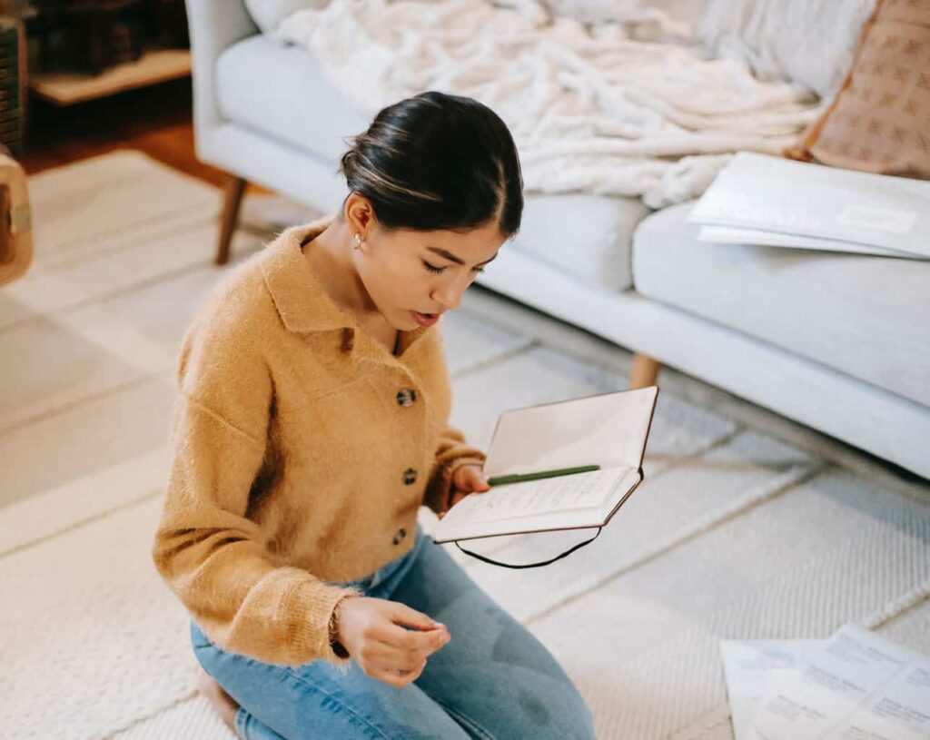 Woman kneeling on floor making a list