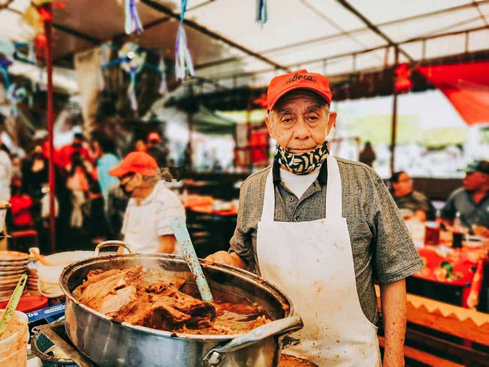Elderly man showing off his carnitas in Quiroga