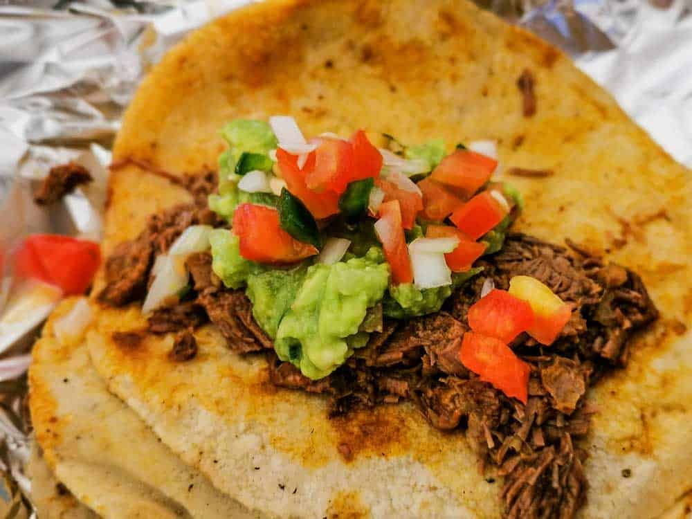 Carnitas taco with park, tomato salsa, and guacamole