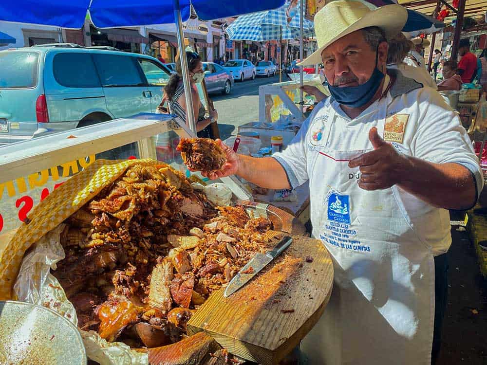 Man holding up carnitas park in Quiroga, Michoacan state, Mexico
