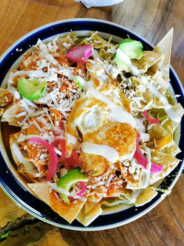 Tortilla chips with raw onions and an egg on top