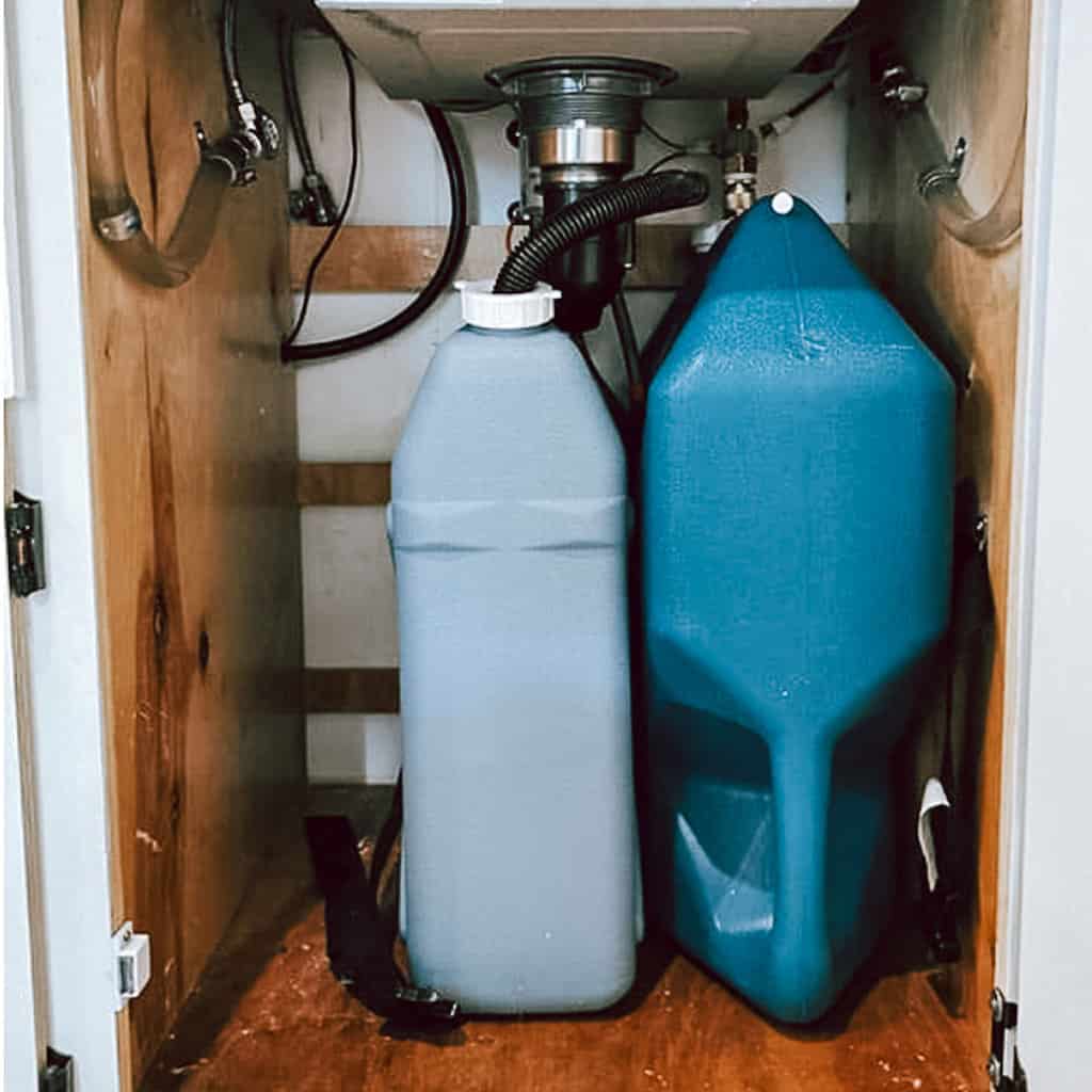 Two water tanks under a camper van kitchen counter