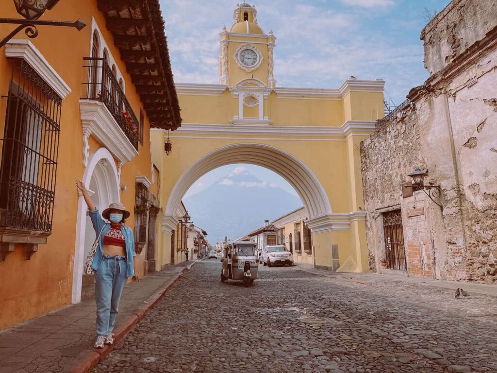 Yuko posing in front of a yellow arch in Antigua, Guatemala