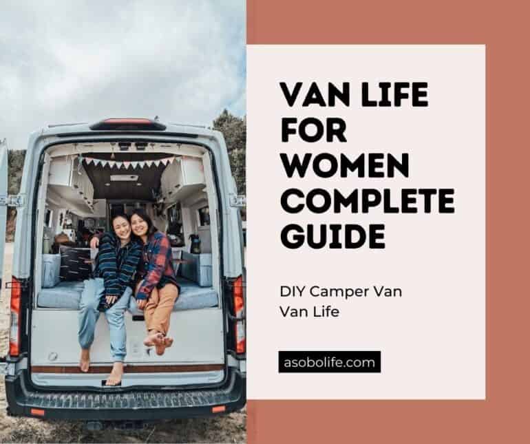 Two women sitting out the back of a camper van