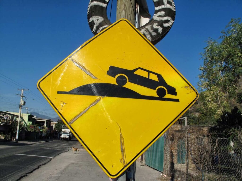 Street sign indicating a speed bump ahead