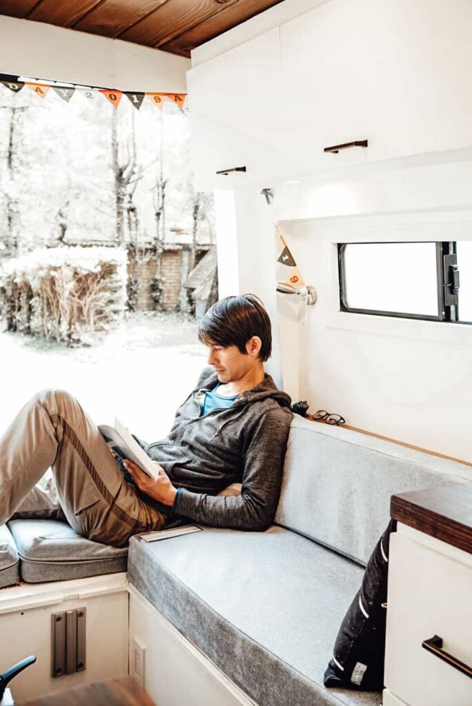 Man sitting and reading inside his camper van