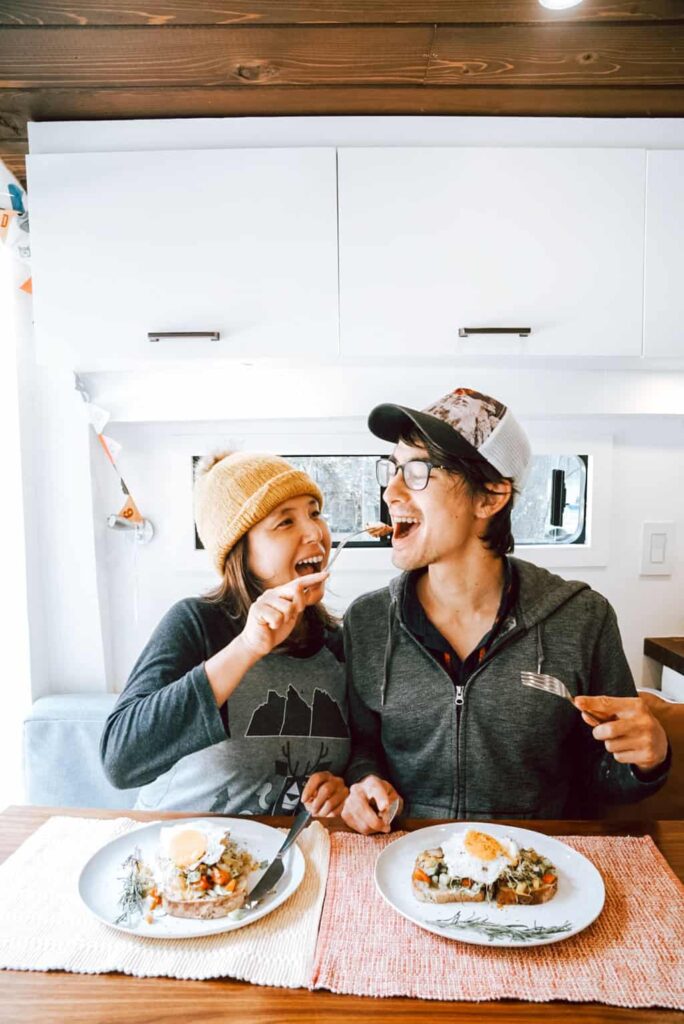 Couple eating breakfast in their camper van