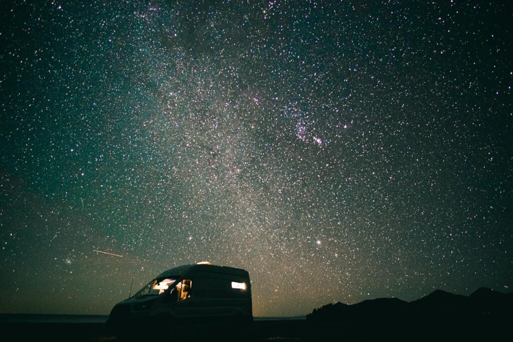 Ford Transit camper van parked at night under the stars