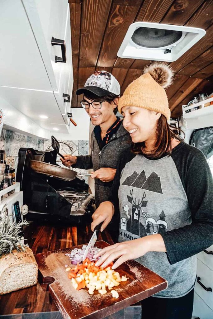 Couple cooking in a camper van