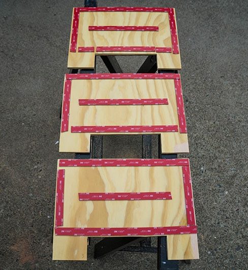 Three pieces of plywood on the floor with 3M VHB tape placed on top