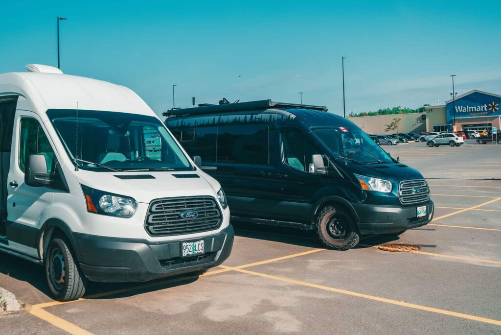 Two camper vans parked at a Walmart parking lot