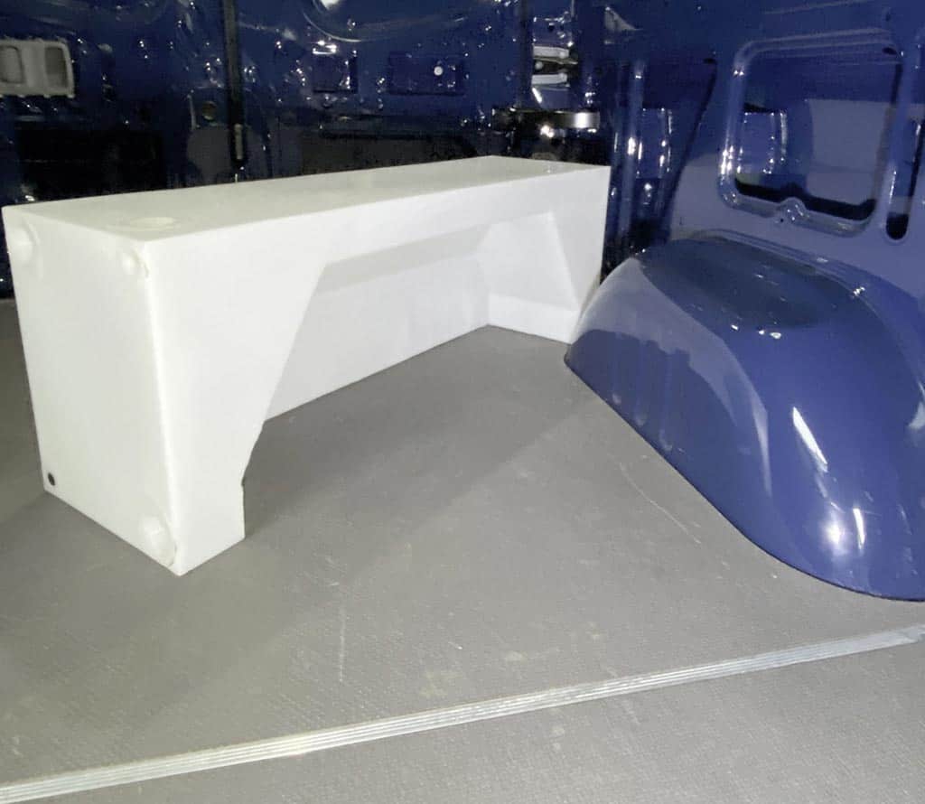 Water tank that fits over the wheel well of a van.