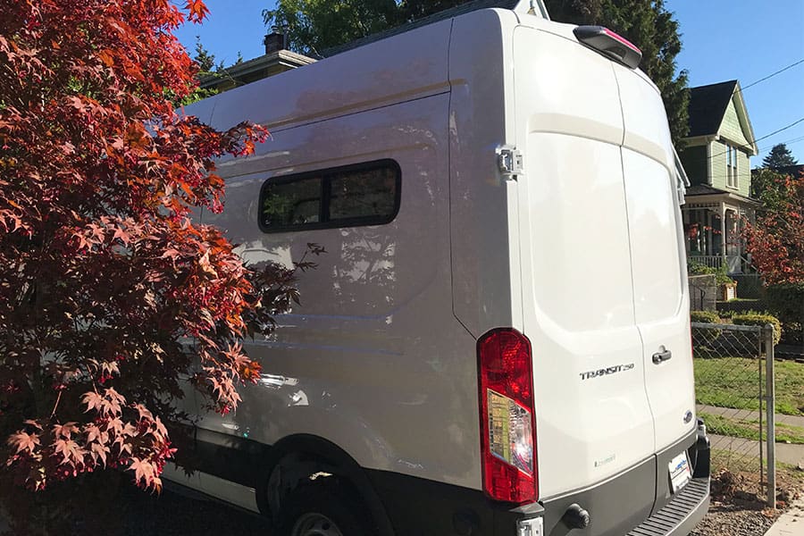 Rear left side of a Ford Transit van showing the half-slider RV window